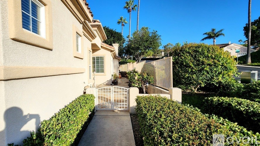 A white house with a gate in the front yard.