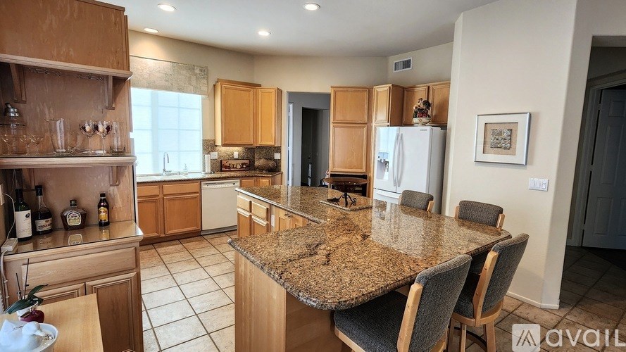 A kitchen with granite countertops and wooden cabinets.