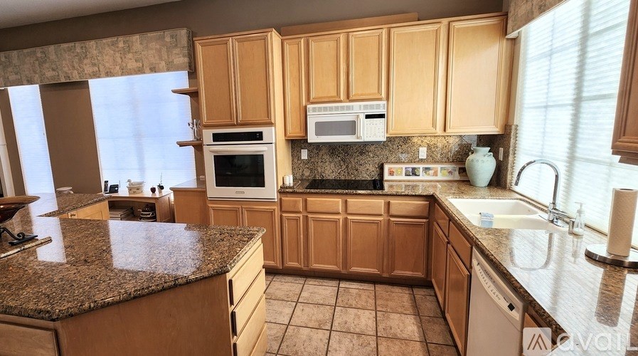 A kitchen with wooden cabinets and granite countertops.