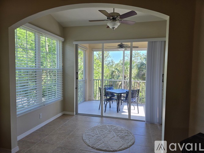 A room with a ceiling fan and sliding glass doors leading to a patio.