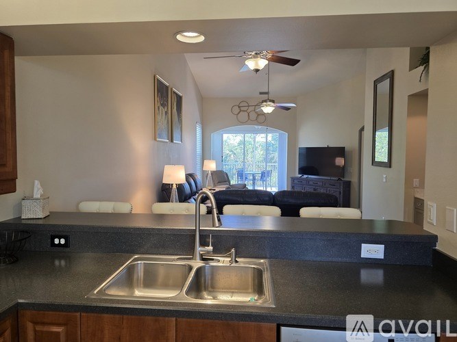 A kitchen with a sink and a ceiling fan.
