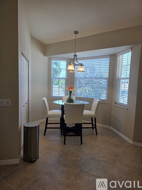 A dining room with a table and chairs.