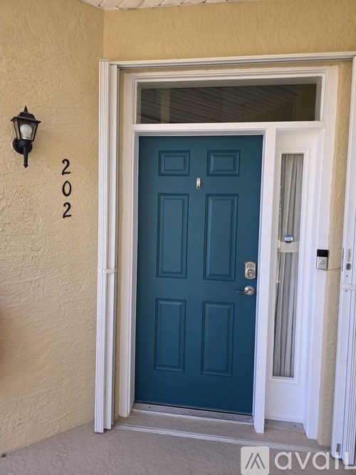 A blue door with a white frame and a black lamp on the wall above it.