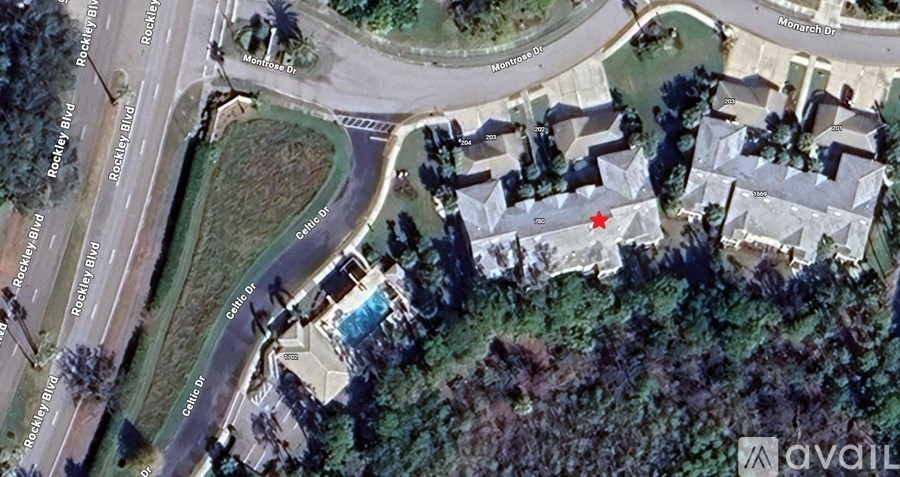 A satellite image shows a residential area with a road passing through it.