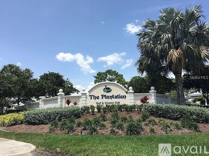 The Plantation Country Club sign is displayed in front of a beautifully landscaped area.