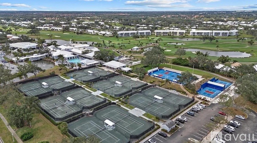 A large outdoor tennis court surrounded by buildings.