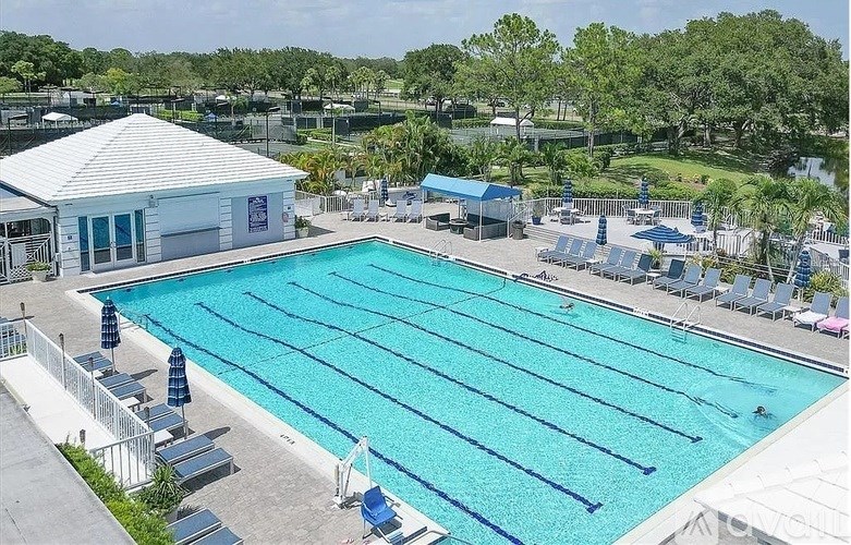 A large swimming pool with multiple lanes and a building in the background.