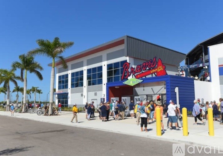 A group of people are standing outside of a building with a red sign that says "Brand's".