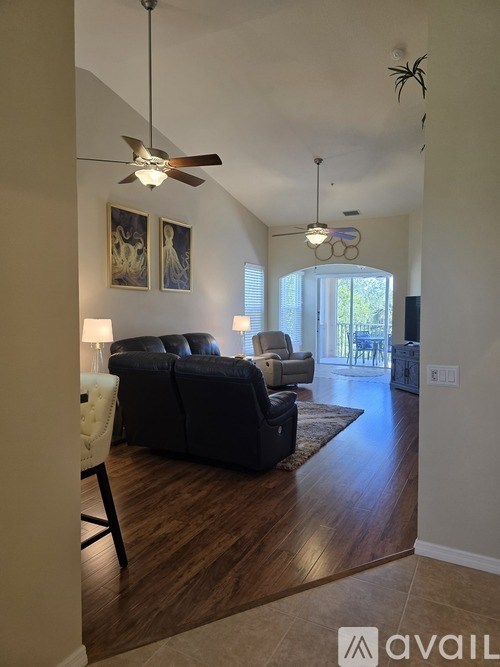 A living room with a dark brown couch and a white chair.