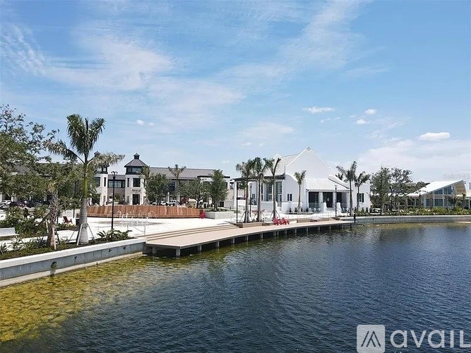 A serene waterfront scene with a dock and buildings in the distance.