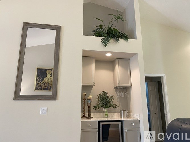 A modern kitchen with a grey countertop and a framed picture on the wall.