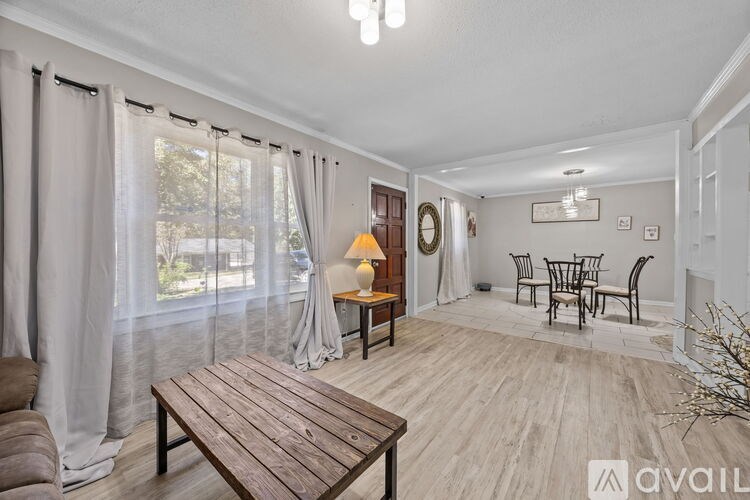 A living room with a wooden table and chairs.