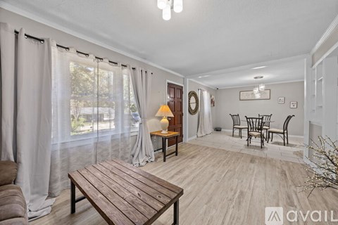 A living room with a wooden table and chairs.