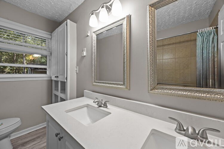 A bathroom with a white sink and a large mirror.