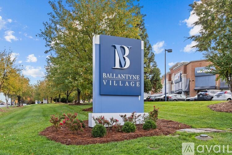 A sign for Ballantyne Village stands in front of a Verizon store.