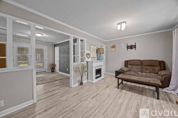 A living room with a brown couch and a fireplace.