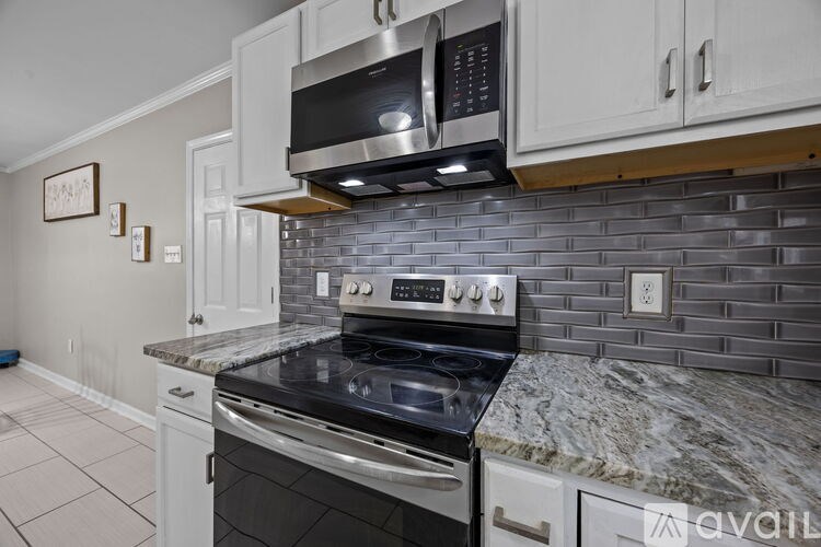 A kitchen with a granite countertop and stainless steel appliances.