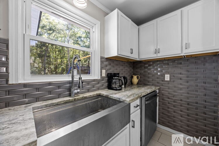 A kitchen with a window overlooking a tree.