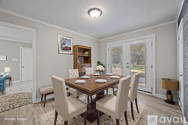 A dining room with a wooden table and chairs.