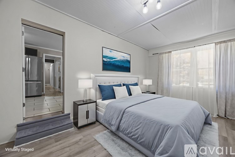 A bedroom with a bed, nightstand, and a painting on the wall.