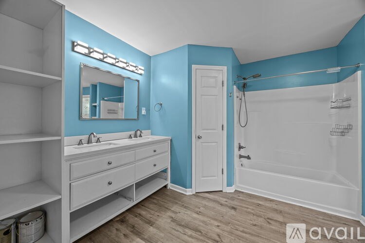 A bathroom with blue walls and a white vanity.
