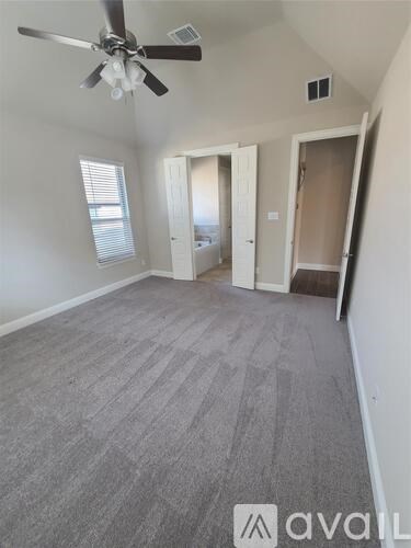 A room with a ceiling fan and carpeted floor.