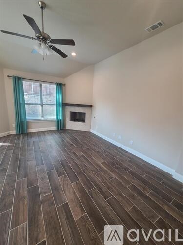 A room with wooden flooring and a ceiling fan.