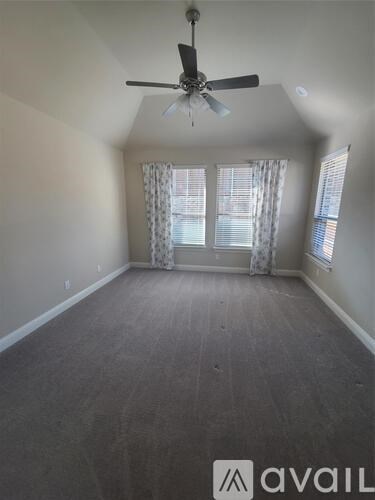 A room with a ceiling fan and carpeted floor.