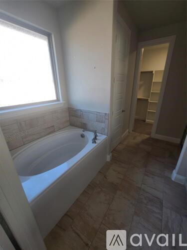A bathroom with a tub and a walk-in closet.