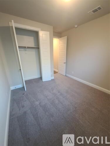 A room with a grey carpet and a white door.