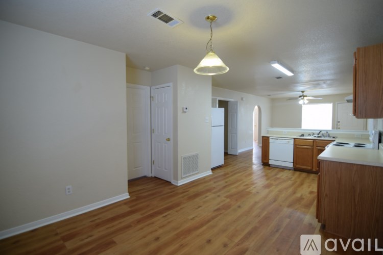A kitchen with wooden floors and white walls.