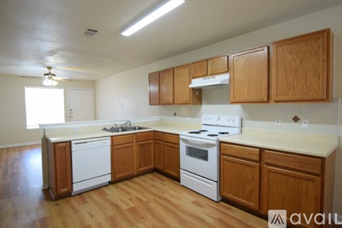 A kitchen with wooden cabinets and white appliances.