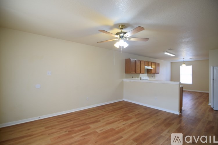 A room with wooden floors and a ceiling fan.