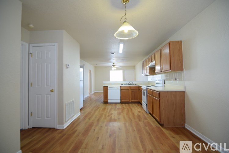 A kitchen with wooden floors and white walls.