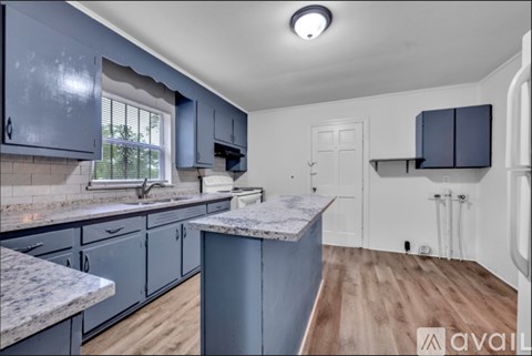 A kitchen with blue cabinets and a marble countertop.
