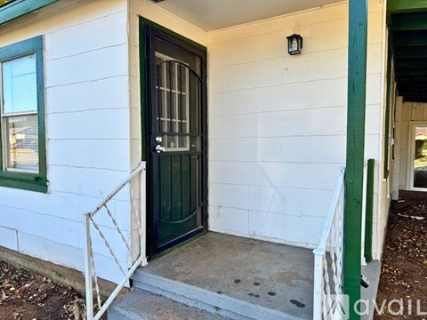 A white house with a green door and a small porch.