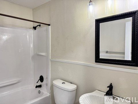 A white toilet sits next to a white sink in a bathroom.