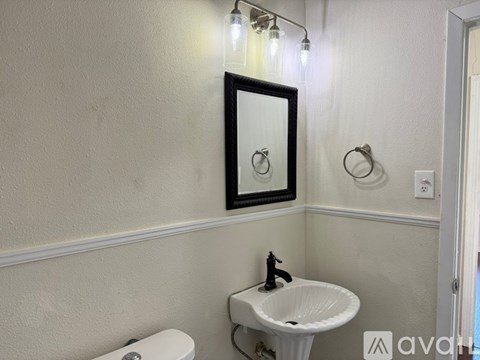 A bathroom with a white sink and a mirror above it.