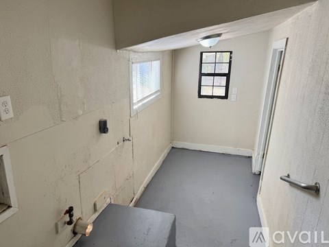 A room with a window, a door, and a wall with a hole in it.