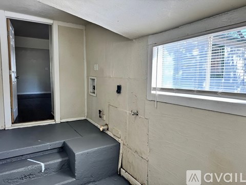 A room with a window, a door, and a step leading to a lower level.