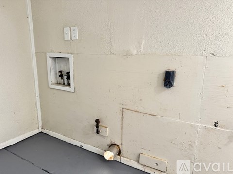A wall with a small window, a switch, and a plug.