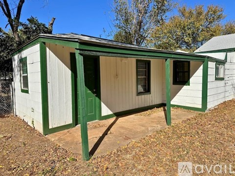 A small white house with green trim and a green door.