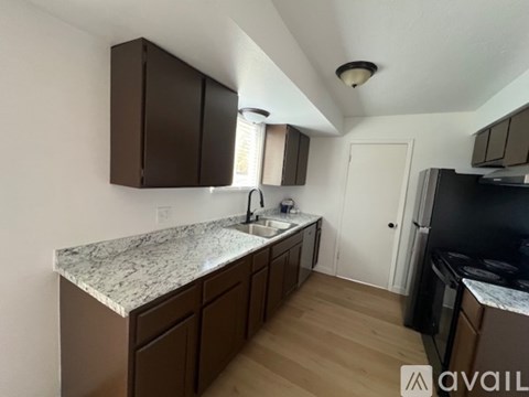A kitchen with brown cabinets and a granite countertop.