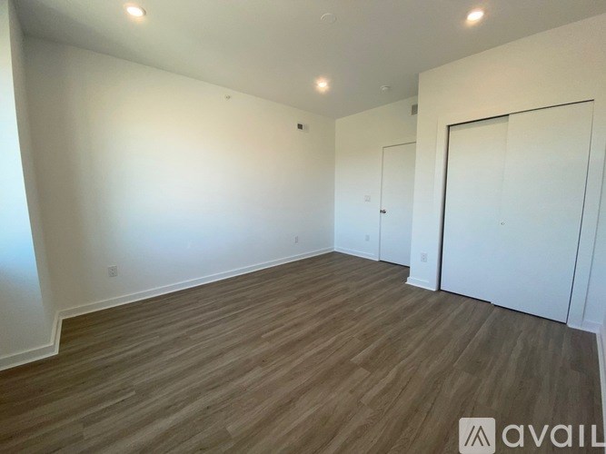 A room with wooden flooring and white walls.