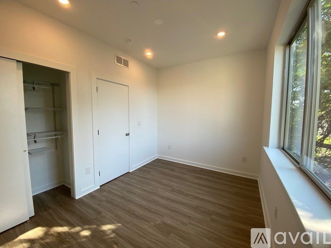 A room with a window on the right side and a door on the left side.