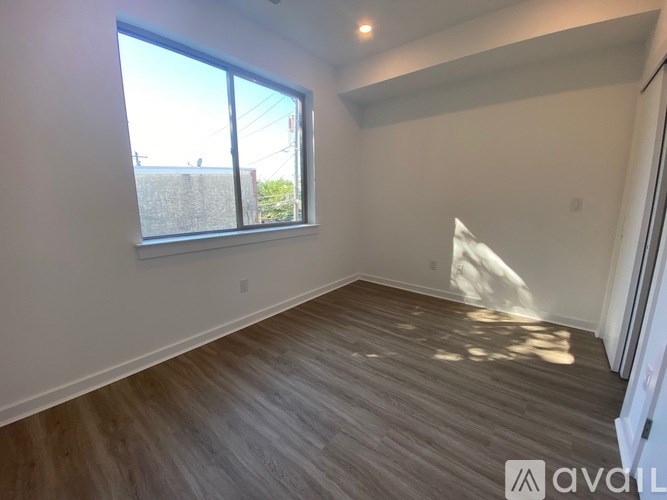 A room with wooden flooring and a large window.