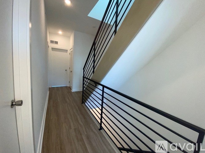 A hallway with a skylight and a black railing.