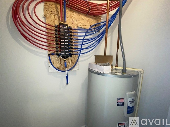 A wall-mounted heating system with red and blue wires.