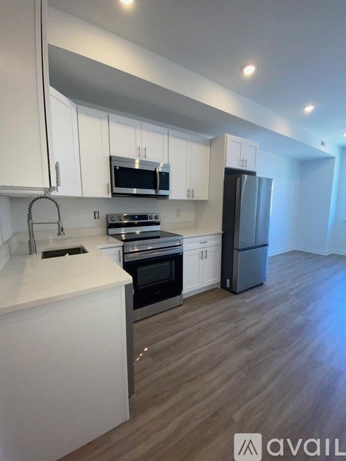 A kitchen with white cabinets and a refrigerator.