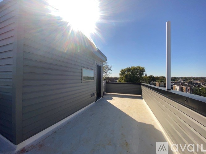 A sunny day with the sun shining on a grey building.